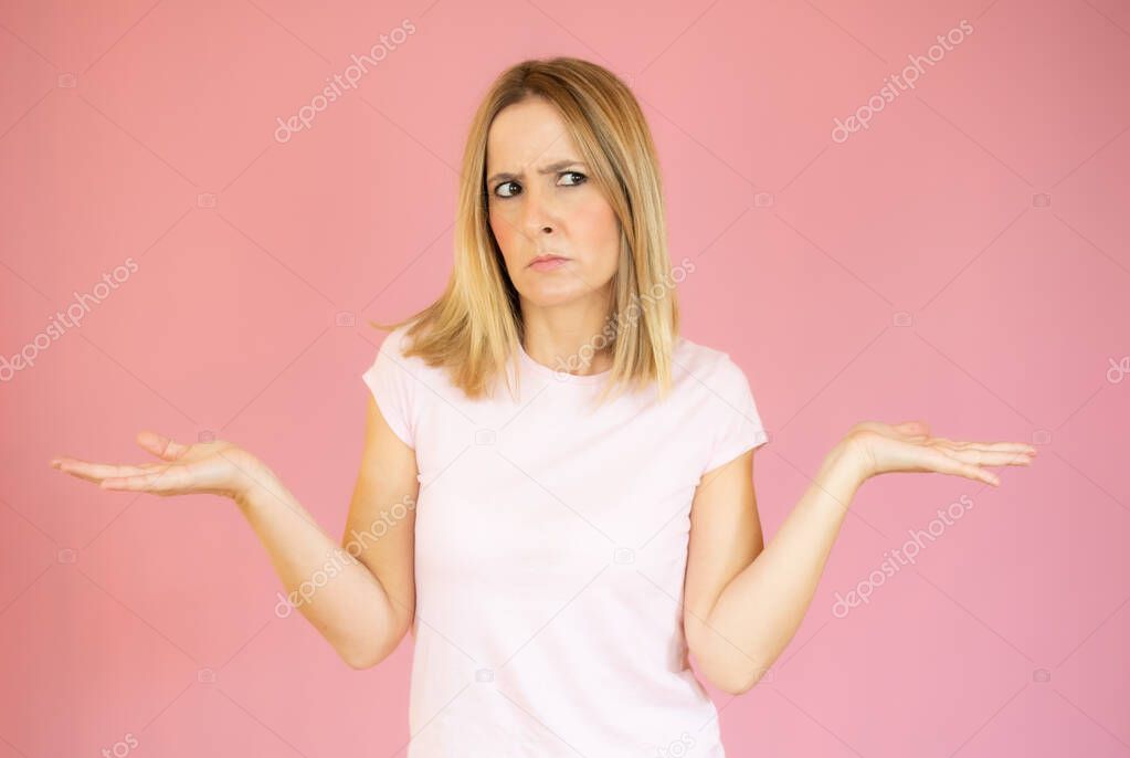 on a pink background young woman throw up his hand