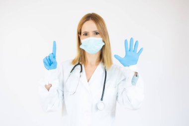 Koruyucu maske ve lateks takan güzel bir kadın doktor ya da hemşire ya da fotokopi çekilen beyaz arka planda lastik eldiven. Sağlık hizmeti kavramı