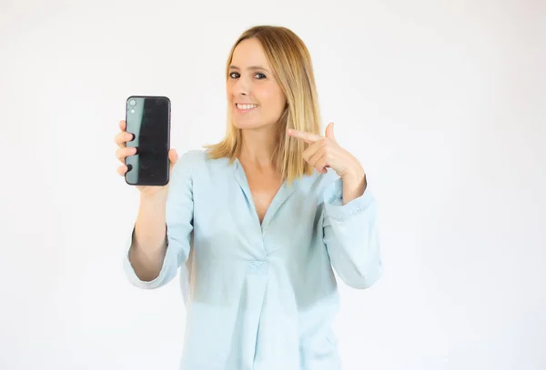 Uśmiechnięta Kobieta Wskazuje Telefon Stojący Białym Tle — Zdjęcie stockowe