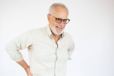 Beyaz arka planda kalça ağrısı olan yaşlı bir adamın portresi ve yakın plan görüntüsü.