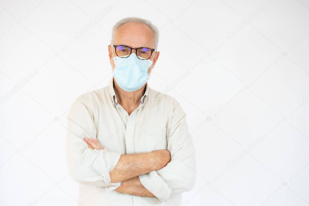 Portrait of cheerful senior man wearing surgical mask looking at camera over white background.