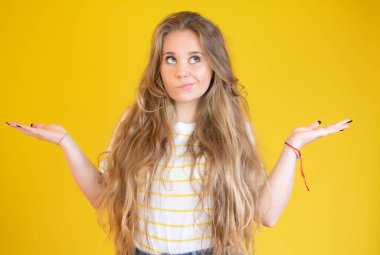 Sarı arka planda genç bir kız ellerini kaldırıyor.