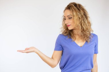 Ürün gösteren bir kadın sürprizi. Yan tarafı kıvırcık saçlı güzel bir kadın. Ürününüzü sunuyorum..