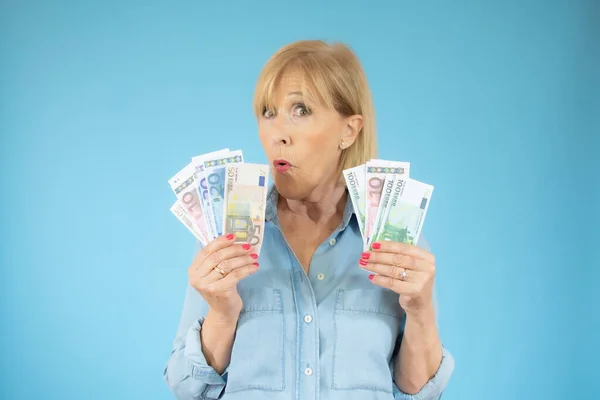 Savings, finances and people concept - smiling senior woman holding money banknotes