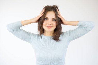 Genç, güzel bir kadın kendini stresli, endişeli, endişeli ya da korkmuş hissediyor, elleri başının üstünde, beyaz arka planda hata yaparak panikliyor..