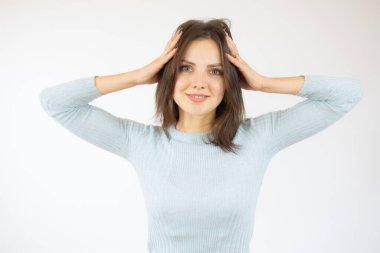 Genç, güzel bir kadın kendini stresli, endişeli, endişeli ya da korkmuş hissediyor, elleri başının üstünde, beyaz arka planda hata yaparak panikliyor..