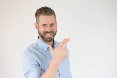 Siyah süveterli çekici bir genç beyaz arka planda parmakları izole bir şekilde yukarı bakıyor.