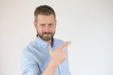 Siyah süveterli çekici bir genç beyaz arka planda parmakları izole bir şekilde yukarı bakıyor.