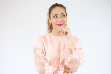 İzole edilmiş arka plan kafa karışıklığı ve soru sorulması üzerine sıradan süveter giyen güzel bir kadın. Şüpheyle kararsız, kafa kafaya düşünerek. Düşünceli kavram.