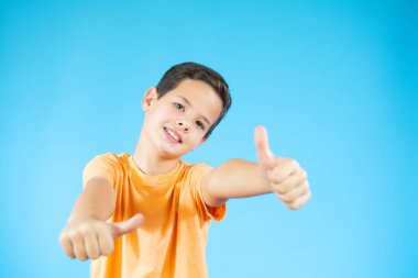 Güzel çocuk mavi arka planda işaret diliyle işaret dilini gösteriyor.