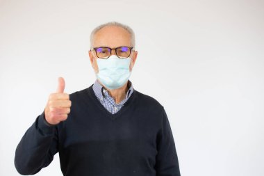 Hastalıkları önlemek için tıbbi ya da cerrahi maske takan olgun bir adamın portresi, beyaz arka plan üzerinde sağlıklı bir emeklinin resmi.