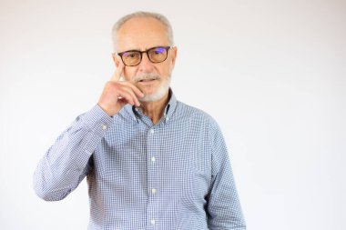 Beyaz arka plan üzerinde duran, beyaz saçlı, son sınıf öğrencisi. Kolları açık, hiçbir fikri yok..