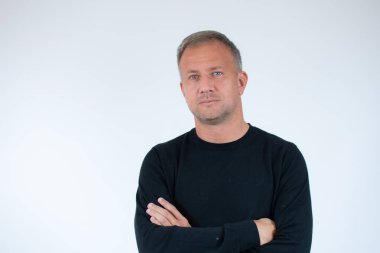 Beyaz arka planda kolları çapraz olan yakışıklı genç adam.