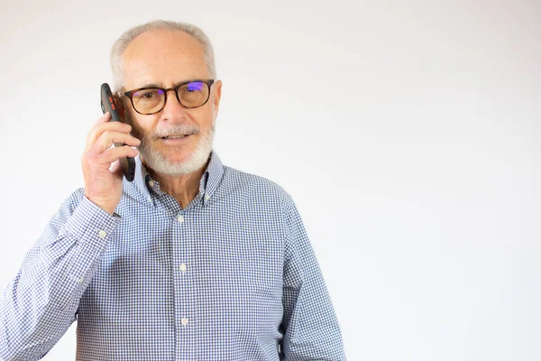 Starší Muž Vede Rozhovor Telefonu Přes Bílé Pozadí Šťastnou Tváří — Stock fotografie