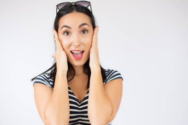 Beyaz arka planda güneş gözlüğü takan genç bir kadının moda portresi..