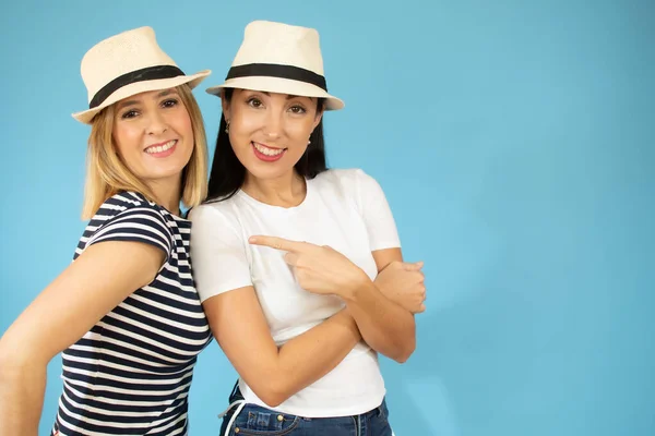 Dvě Veselé Hezké Mladé Dívky Usmívají Kloboukem Izolované Přes Modré — Stock fotografie