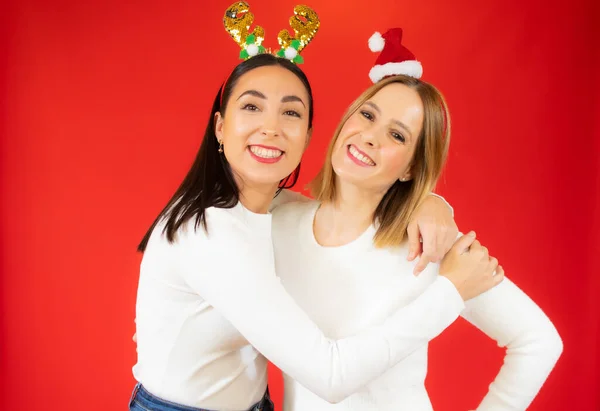 Deux Jolies Femmes Posant Souriantes Avec Pull Blanc Fond Rouge — Photo