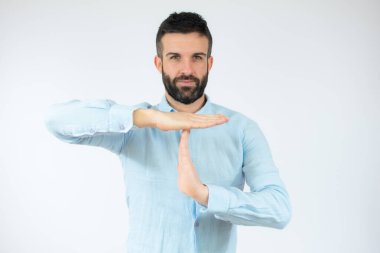 Yakışıklı genç adam gündelik gömlekler giyiyor. Elleriyle jest yapıyor, hayal kırıklığına uğramış ve ciddi bir yüz ifadesi takınıyor.