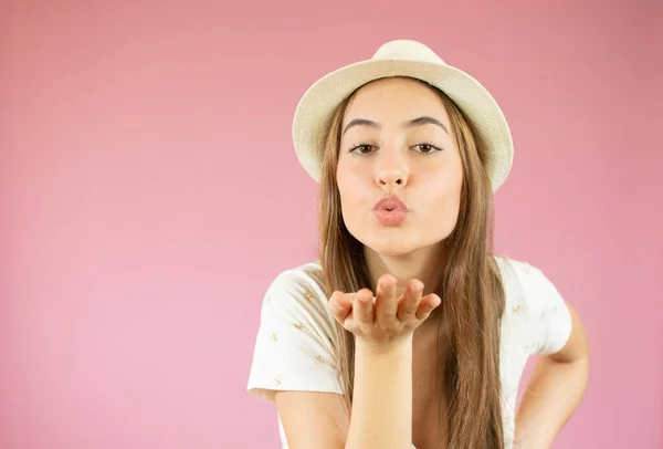 Schöne Junge Frau Mit Strohhut Sendet Luftkuss Auf Rosa Hintergrund — Stockfoto