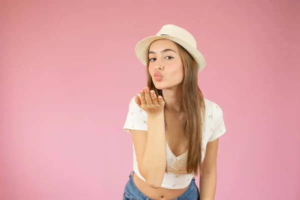 Красивая Молодая Женщина Соломенной Шляпе Посылает Воздушный Поцелуй Розовый Фон — стоковое фото