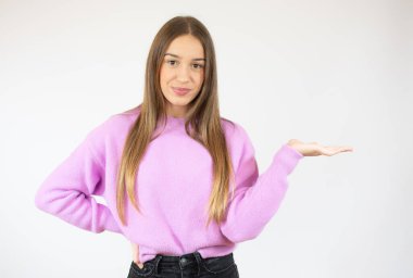 İzole edilmiş beyaz duvardaki genç kız bir ilan vermek için avucunun içinde fotokopi alanı tutuyor.