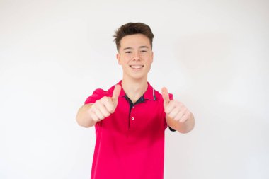 Genç, yakışıklı, zayıf adam beyaz arka planda baş parmak gösteriyor. Stüdyo resmi.