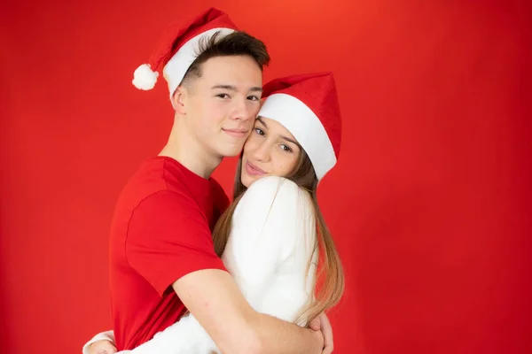 Sorrindo Jovem Casal Abraçando Uns Aos Outros Santa Chapéu Sobre — Fotografia de Stock