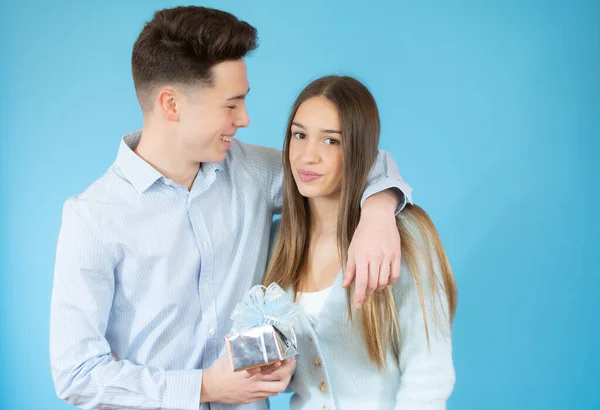 Menino Dando Presente Para Menina Sobre Fundo Azul — Fotografia de Stock