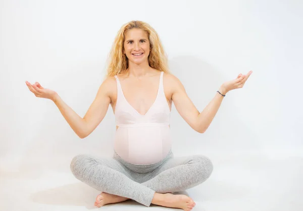 妊娠中の女性リラックスヨガ 上の蓮の位置に座って白い背景 — ストック写真