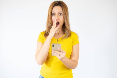 İzole edilmiş arka planda cep telefonu kullanan genç bir kadın. Zeki yüzünde kendine güvenen bir ifade var.