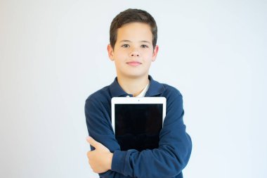 Beyaz bir arkaplanda tablet bilgisayar kullanan sevimli bir çocuğun portresi..