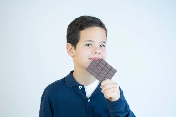 Criança Morde Uma Barra Chocolate Marrom Sobre Fundo Branco — Fotografia de Stock