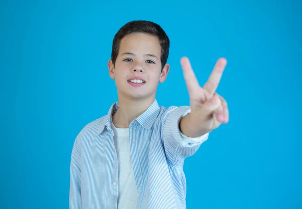 Porträtt Liten Pojke Visar Seger Hand Tecken Blå Bakgrund — Stockfoto