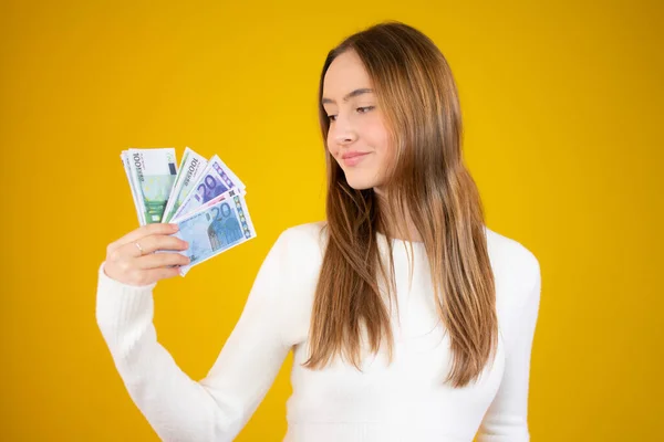 Joven Hermosa Chica Caucásica Sosteniendo Dinero Sobre Fondo Amarillo — Foto de Stock