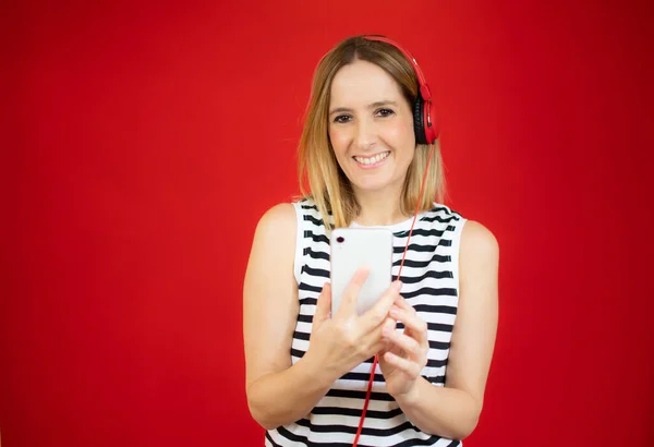 Woman Holding Cellphone Listening Music Earphones Red Background — Stock Photo, Image