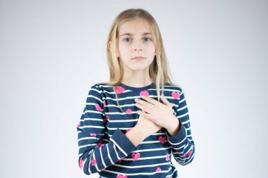 Minnettarlık hisseden küçük samimi kız beyaz arka planda soyutlanmış gibi duruyor..