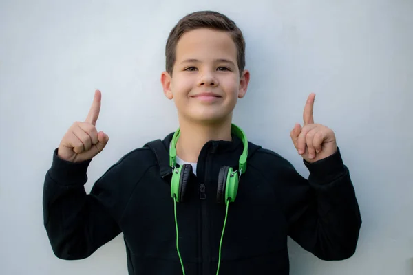 Ung Leende Pojke Med Hörlurar Pekande Uppåt — Stockfoto