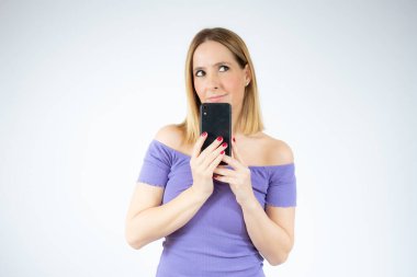Beyaz arka planda izole edilmiş, cep telefonu kullanan güzel bir kadının portresi..