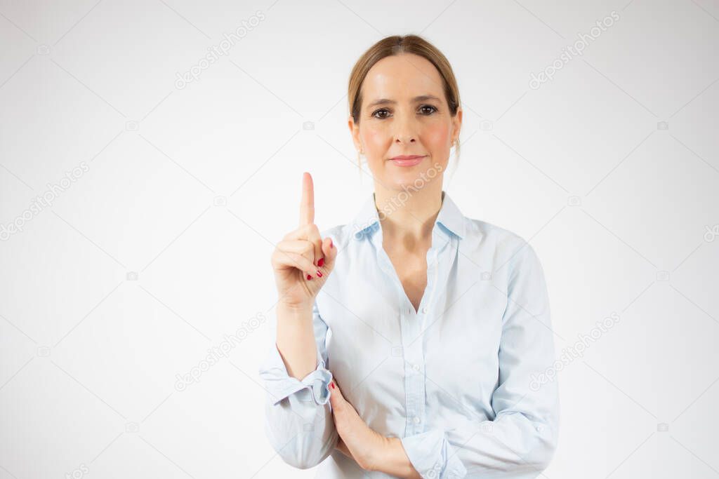 Portrait of young business woman pointing up over white background