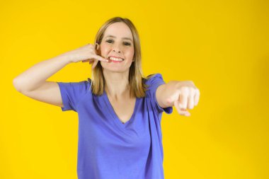 Genç, gülümseyen bir kadın sarı arka planı bana imzalattı..