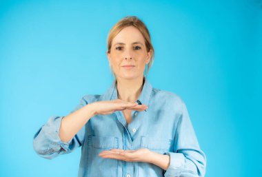 Tecrit edilmiş genç bir kadın iki eliyle bir şey tutuyor, ürün sunumu.