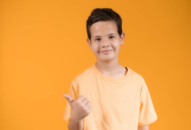 Portakal rengi arka planda izole edilmiş mutlu çocuk portresi.