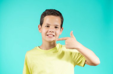 Yeşil arka planda gülümseyen genç bir çocuğun portresi