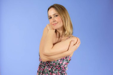 Yazlık elbiseli güzel bir kadının portresi kendine sarılıyor. Bencil duygu kavramı.