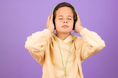 childhood, technology and people concept - smiling boy with headphones over violet background