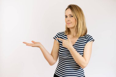 İzole edilmiş beyaz arka planda genç bir kadın, parmağını yana doğru gösteriyor.