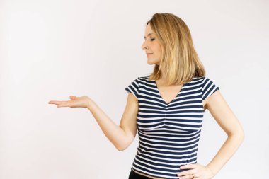 Beyaz arkaplanda boş bir alan tutan gülümseyen kadının resmi..