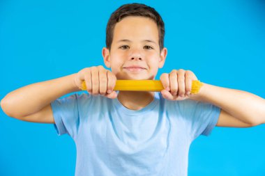 Cute smiling boy holding traditional Italian spaghetti in his hands.