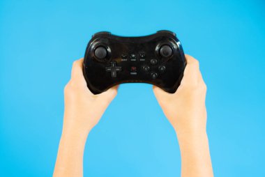 Boy playing video games holding PlayStation gaming controller in hands