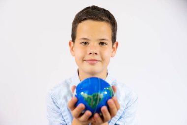 Closeup portrait of school boy holding a world globe isolated over white background